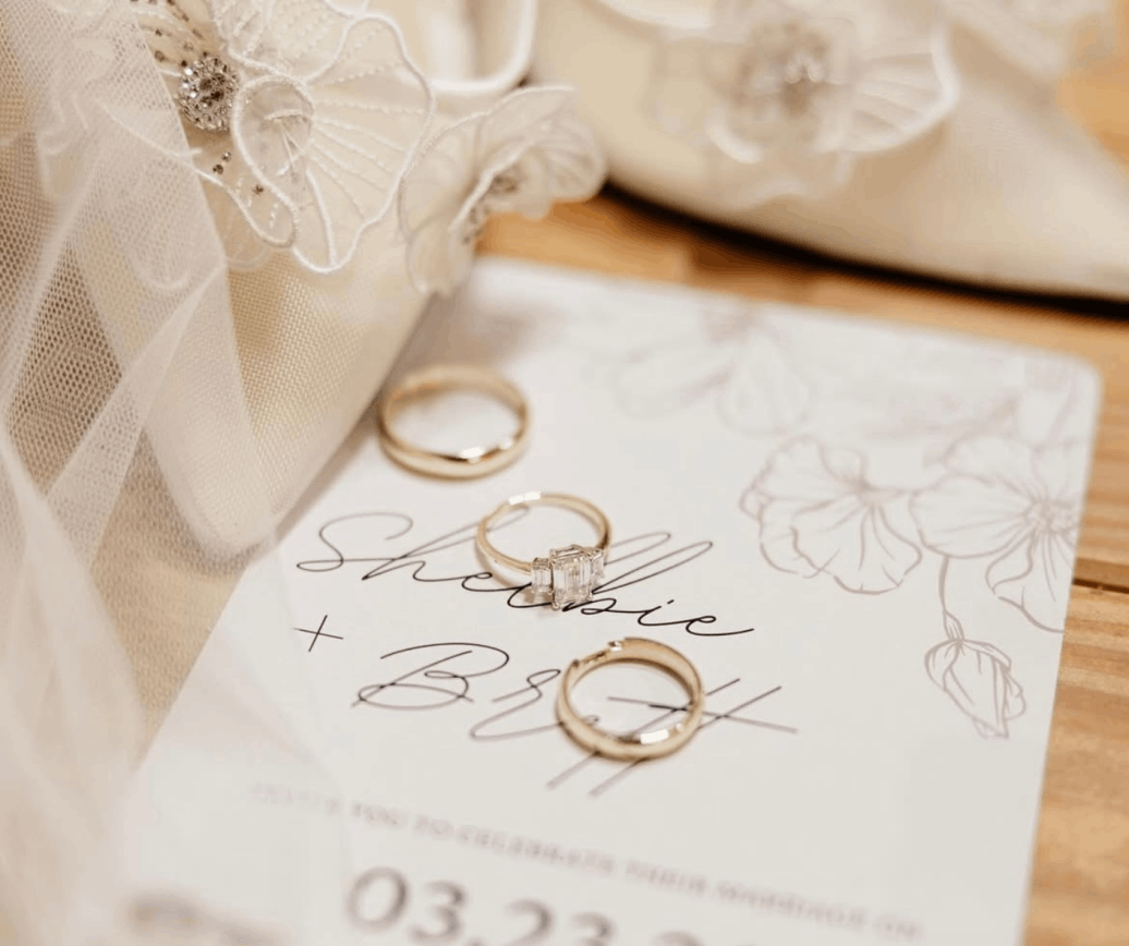 Wedding rings and invitation card for Shellie and Brett with white bridal shoes